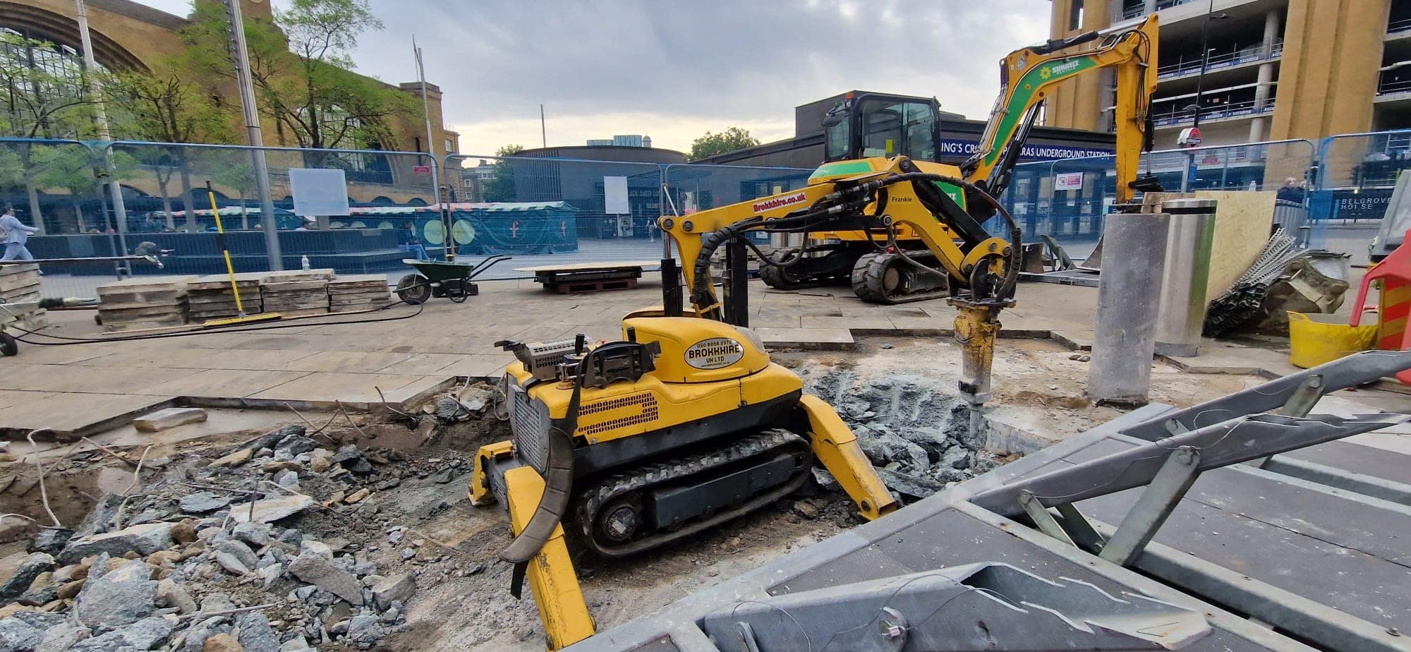 Civils & Groundworks Yellow construction equipment working on a building site with rubble and machinery around.