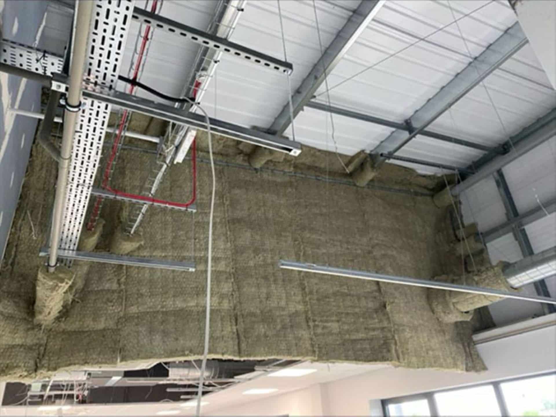 Fire curtain installed on the ceiling of an industrial building with exposed beams and pipes.