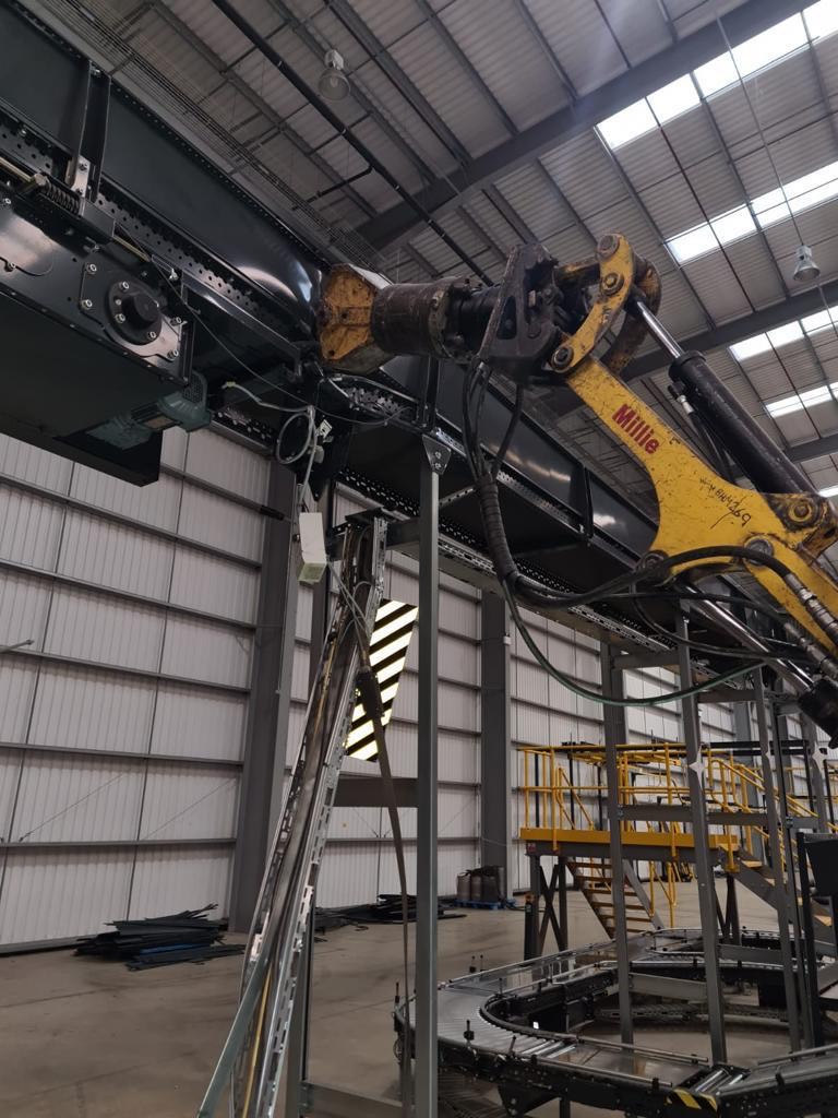 dilaps SCK02 Yellow industrial robotic arm working inside a large factory building.