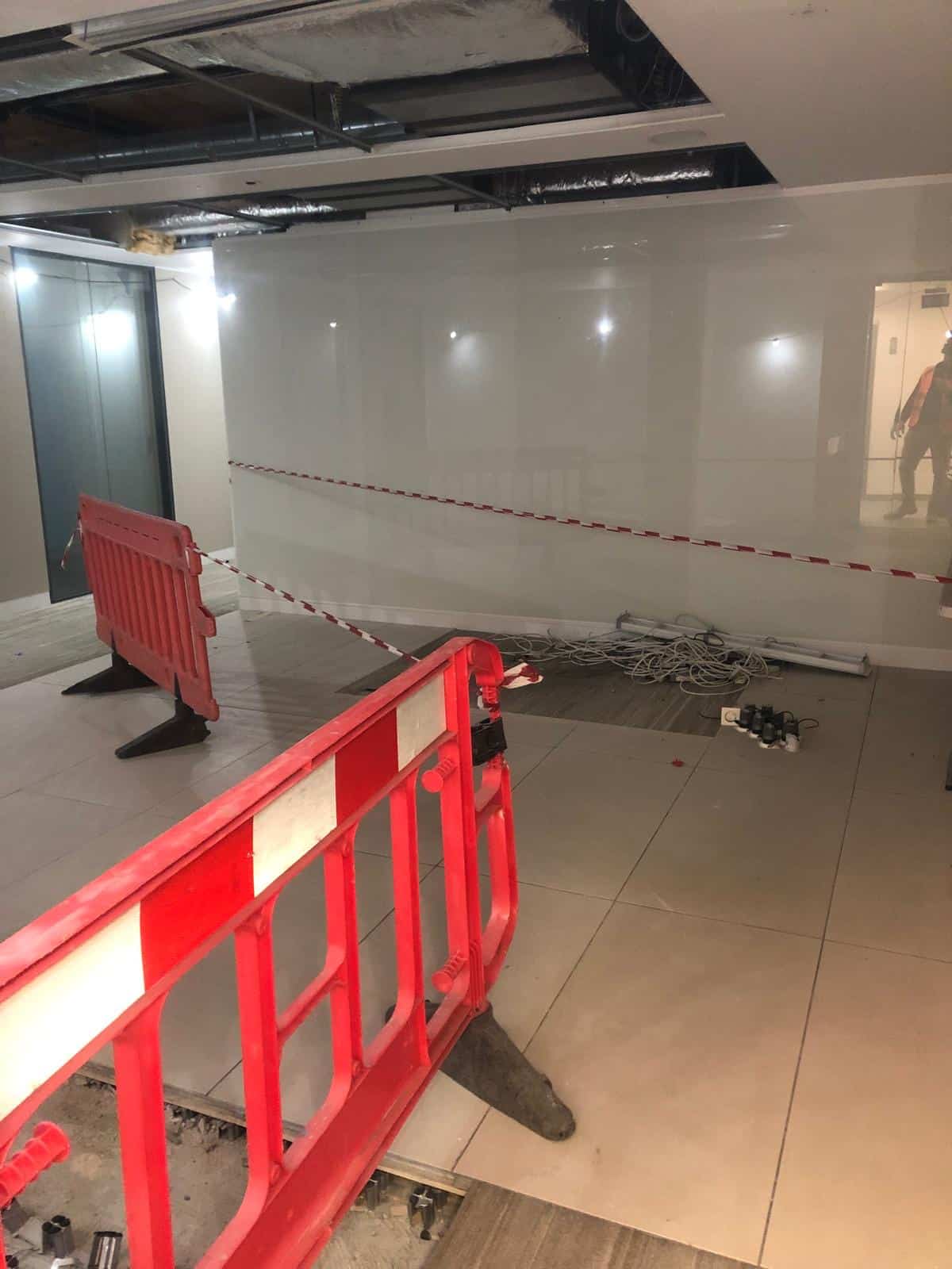 jermyn street1 Red barriers and caution tape block off a construction area inside a building.