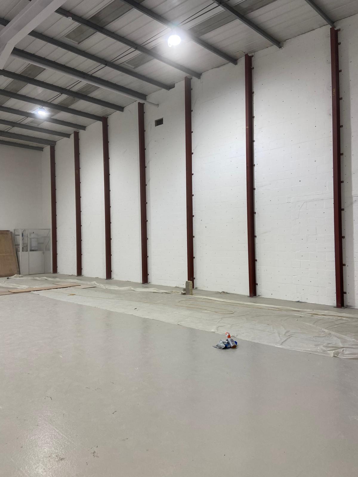 steels08 Interior of an empty warehouse with white walls and exposed steel beams.